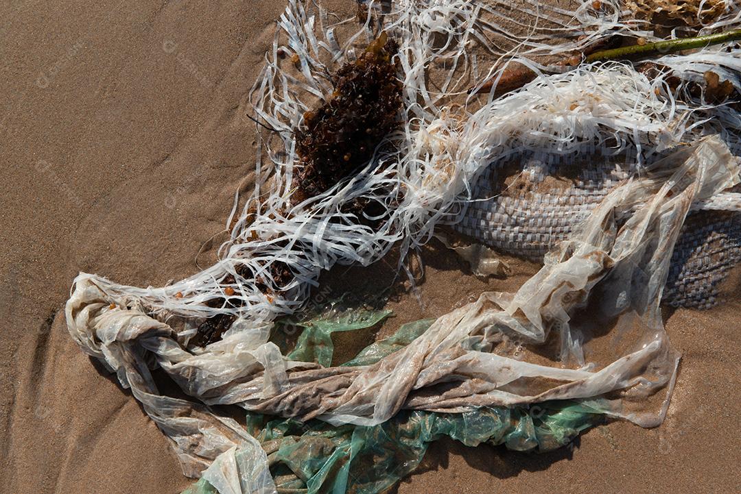 Areia da praia com restos de plástico e lixo em João Pessoa, Paraíba