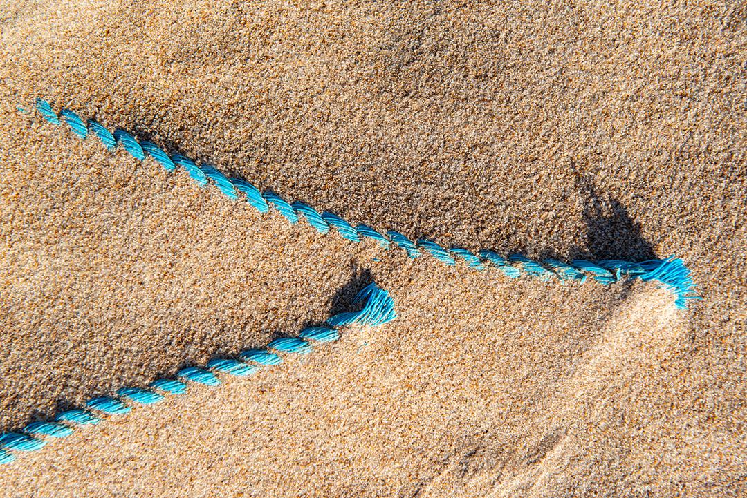 Areia da praia com restos de plástico e lixo em João Pessoa, Paraíba