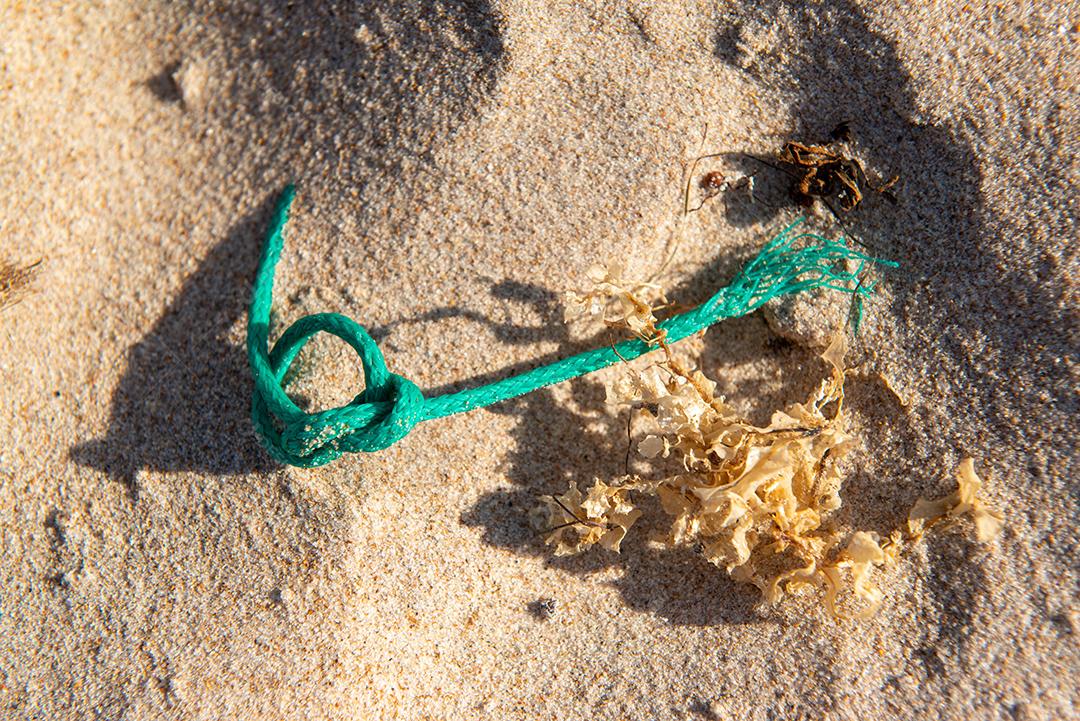 Areia da praia com restos de plástico e lixo em João Pessoa, Paraíba