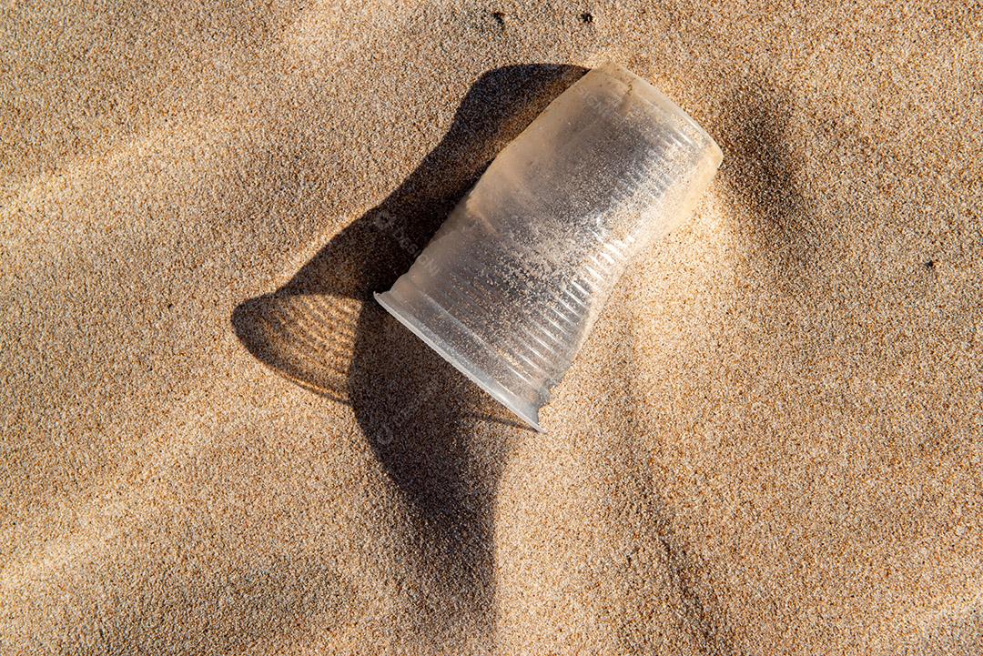 Copo plástico descartável areia causando poluição praia próximo cidade de João Pessoa