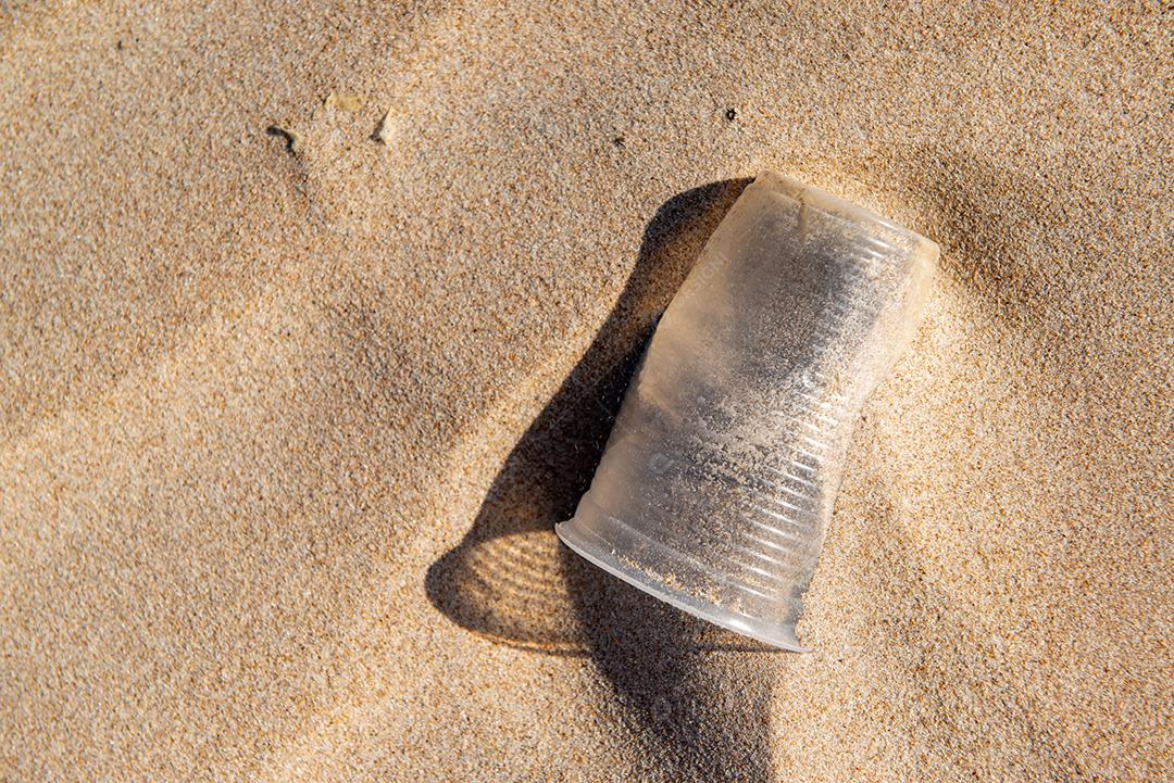 Copo plástico descartável areia causando poluição praia próximo cidade de João Pessoa