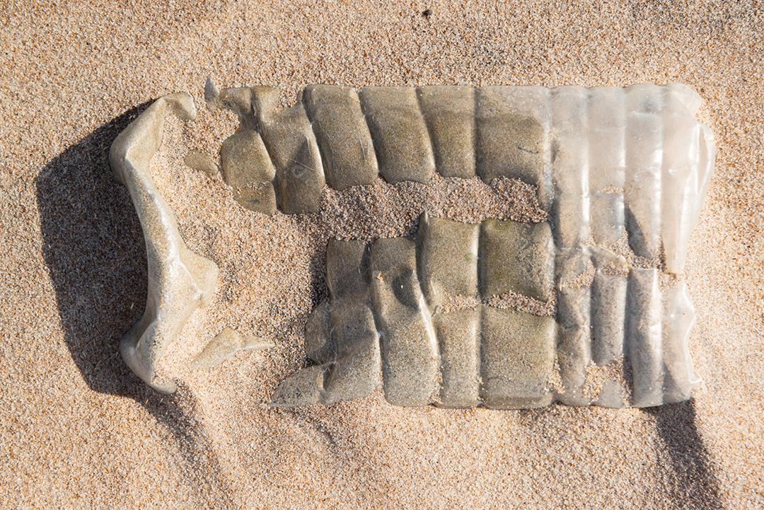 Garrafa plástica na areia, causando poluição praia Poço, próximo à cidade João Pessoa