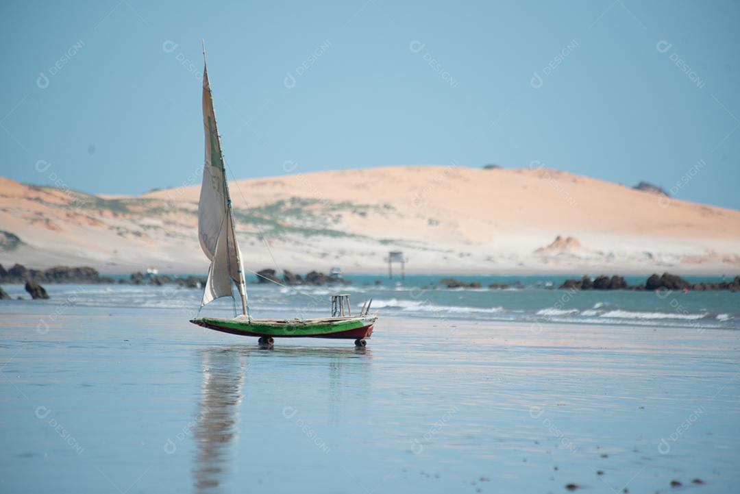 Penhascos coloridos, dunas e pequeno barco à vela manhã cedo praia de Peroba, Icapuí