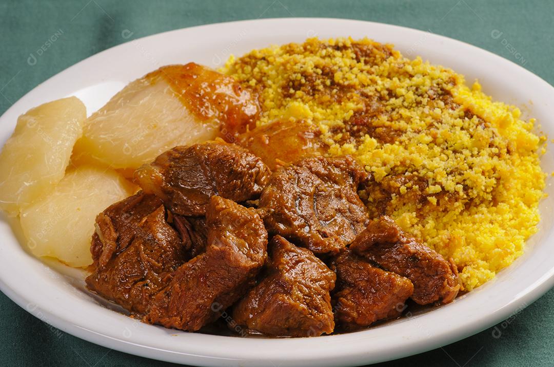 Carne estufada com cuscuz e mandioca. Culinária popular do nordeste do Brasil.