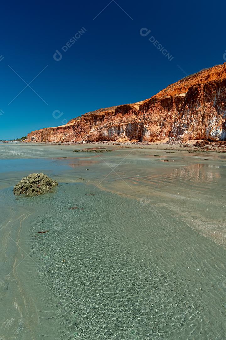 Penhasco de areias coloridas em tons de vermelho, laranja, amarelo e branco Praia de Vila Nova