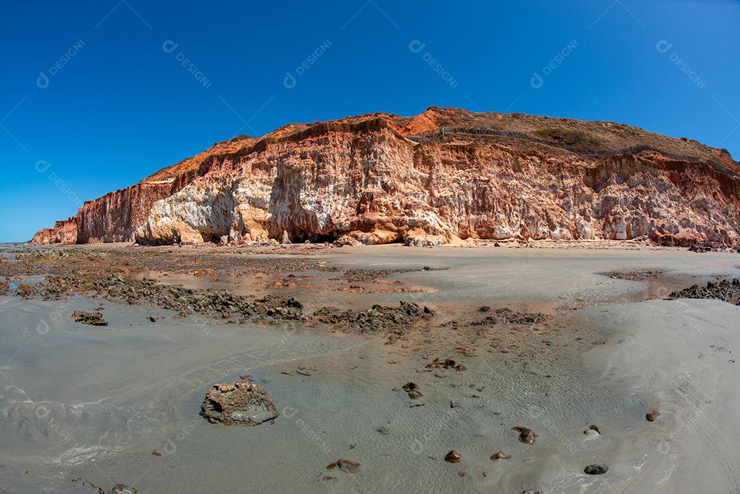 Penhasco de areias coloridas em tons de vermelho, laranja, amarelo e branco Praia de Vila Nova