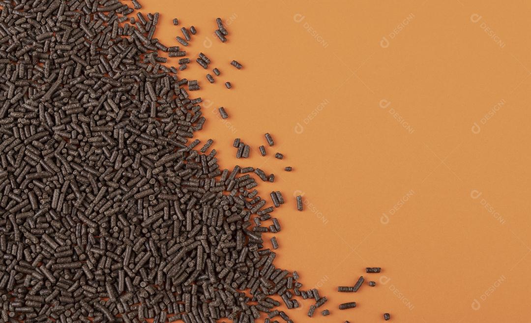 Chocolate escuro polvilha sobre fundo laranja com espaço de cópia JPG