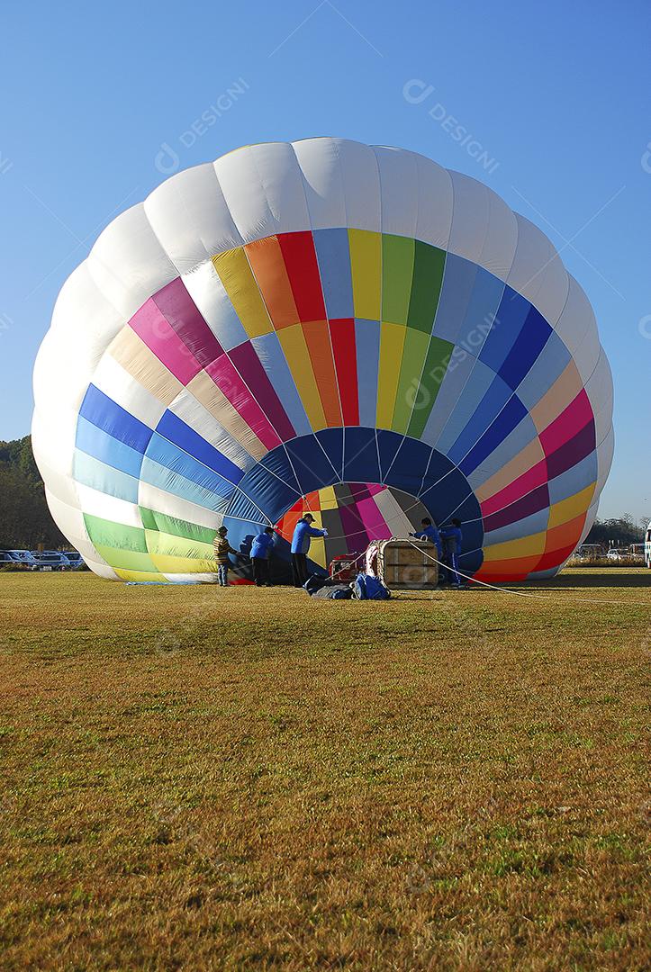 Pessoas enchendo um balão de ar quente para competição