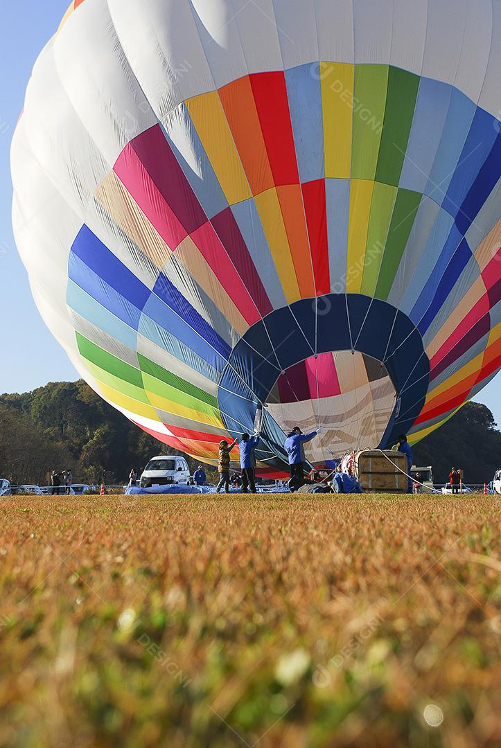 Pessoas enchendo um balão de ar quente para competição