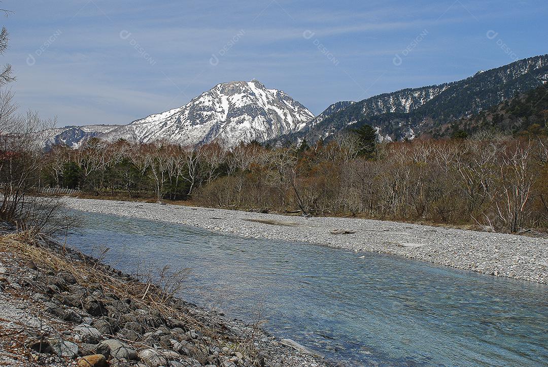 Montanhas cobertas de neve ao fundo e lago claro na cena de inverno em Kamikochi, Japão