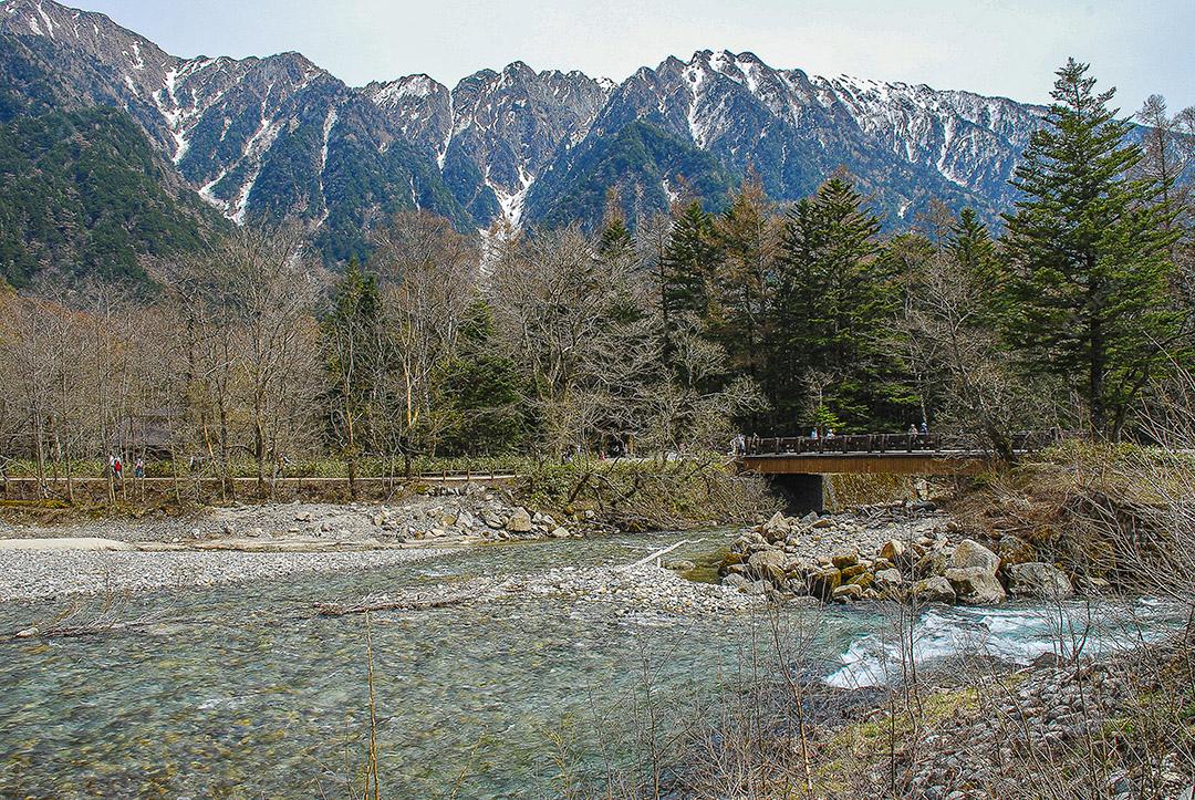 Montanhas cobertas de neve ao fundo e lago Kamikochi, Japão