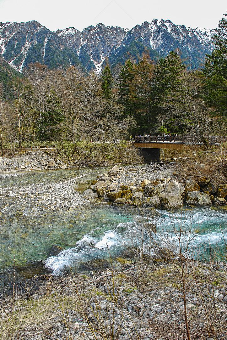 Snow-covered mountains in the background and Lake Kamikochi, Japan