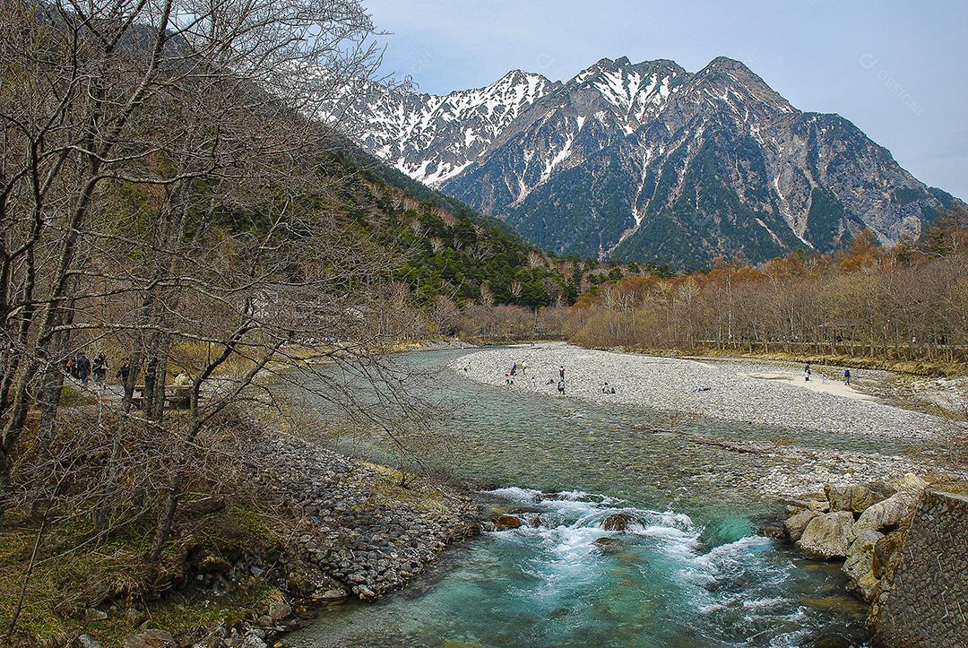 Montanhas cobertas de neve ao fundo e lago Kamikochi, Japão