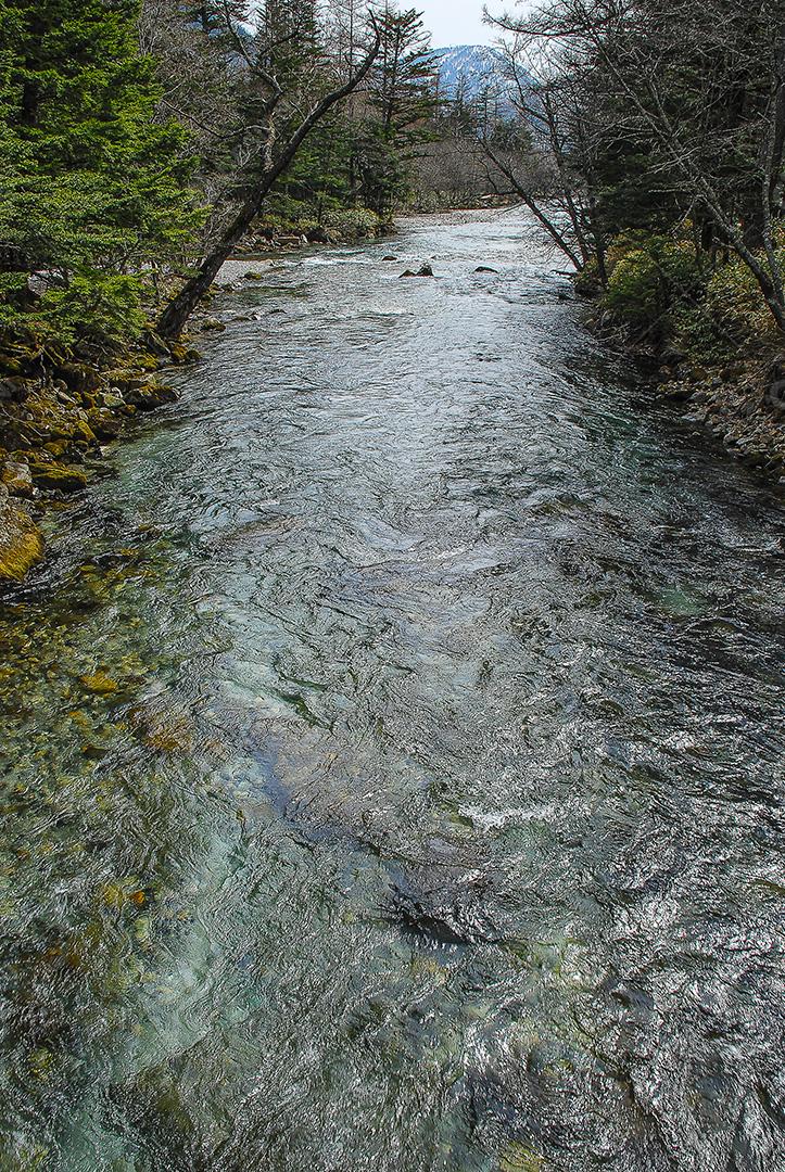 Montanhas cobertas de neve ao fundo e lago Kamikochi, Japão