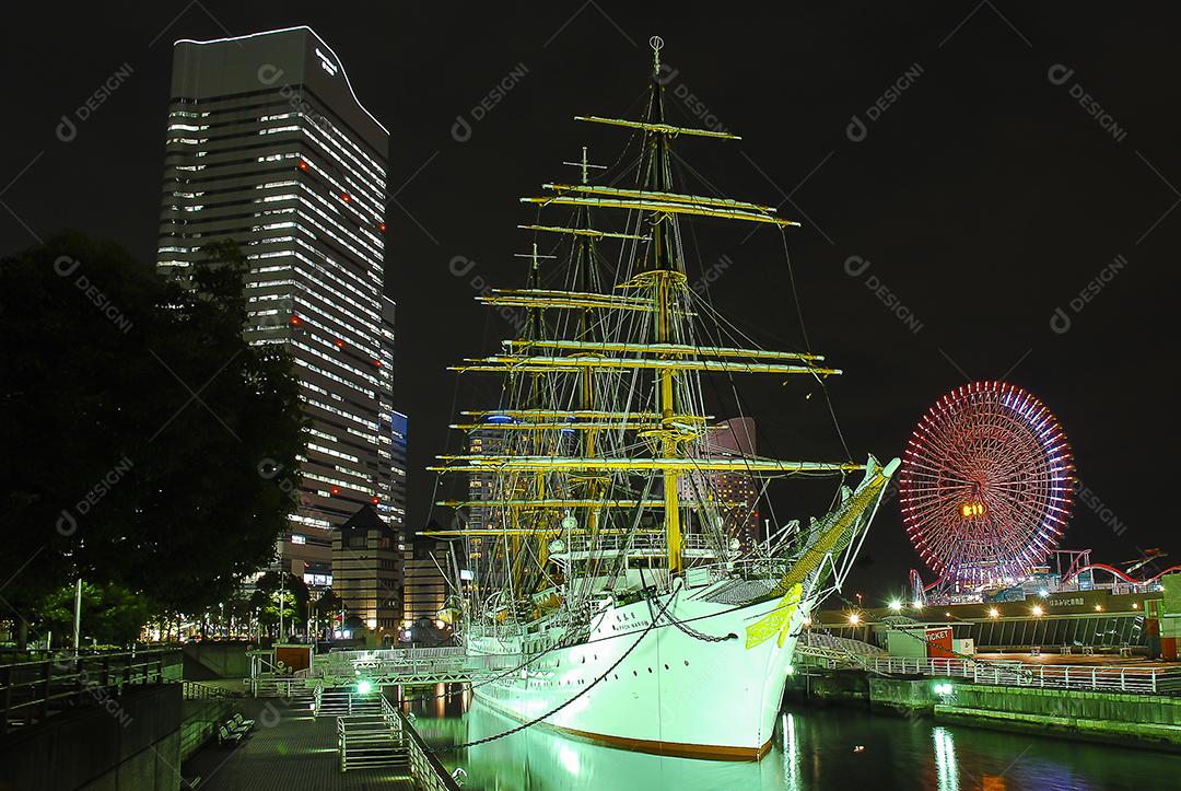 Vista noturna de Yokohama, Japão com belo barco em evidência