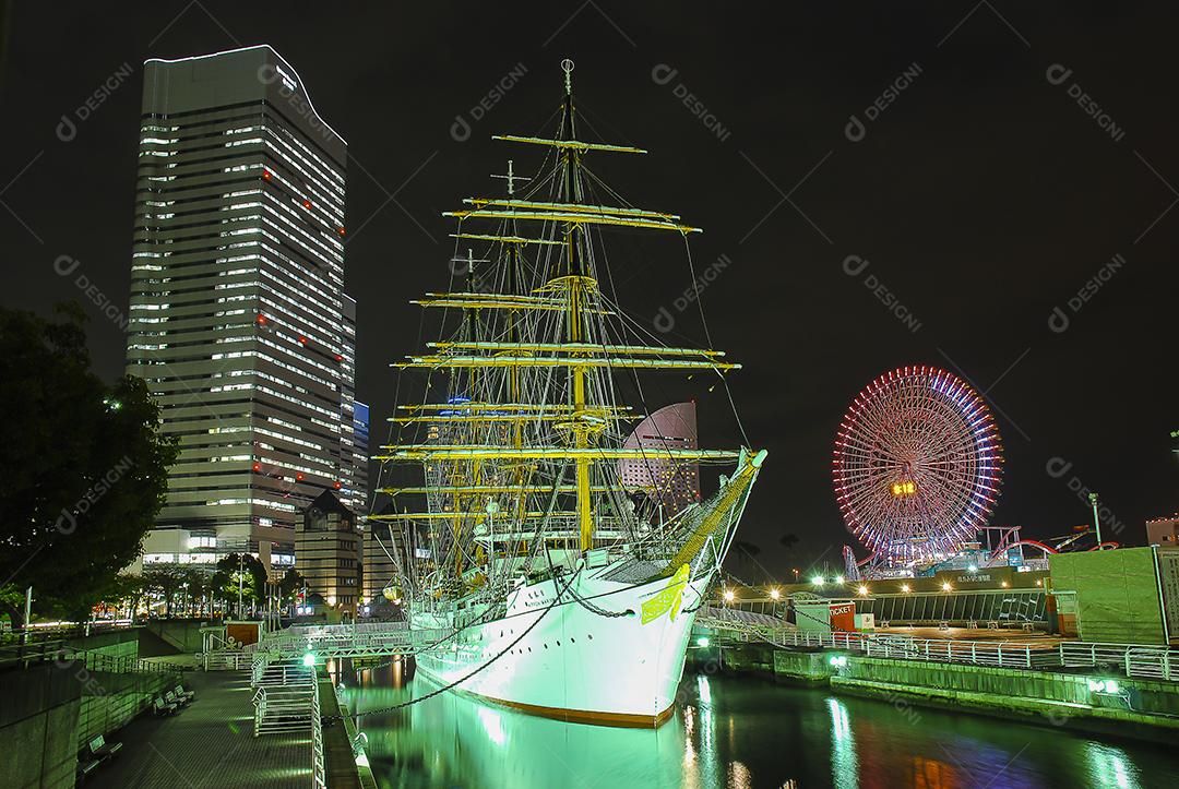 Vista noturna de Yokohama, Japão com belo barco em evidência
