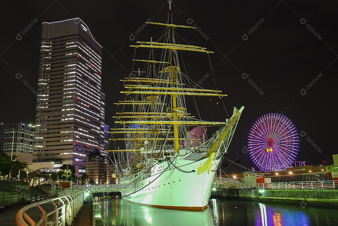 Vista noturna de Yokohama, Japão com belo barco em evidência