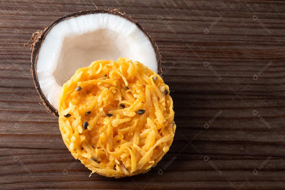 Doce de coco cocada em fundo de madeira rústica
