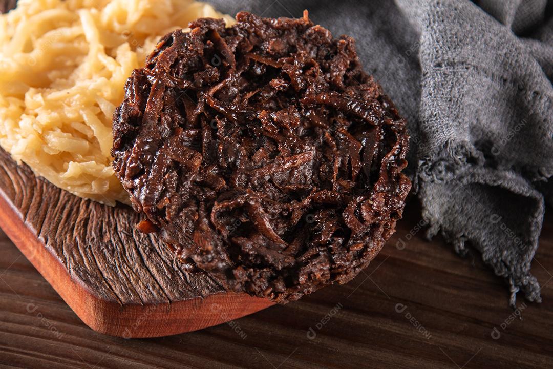 Doce de coco cocada em fundo de madeira rústica