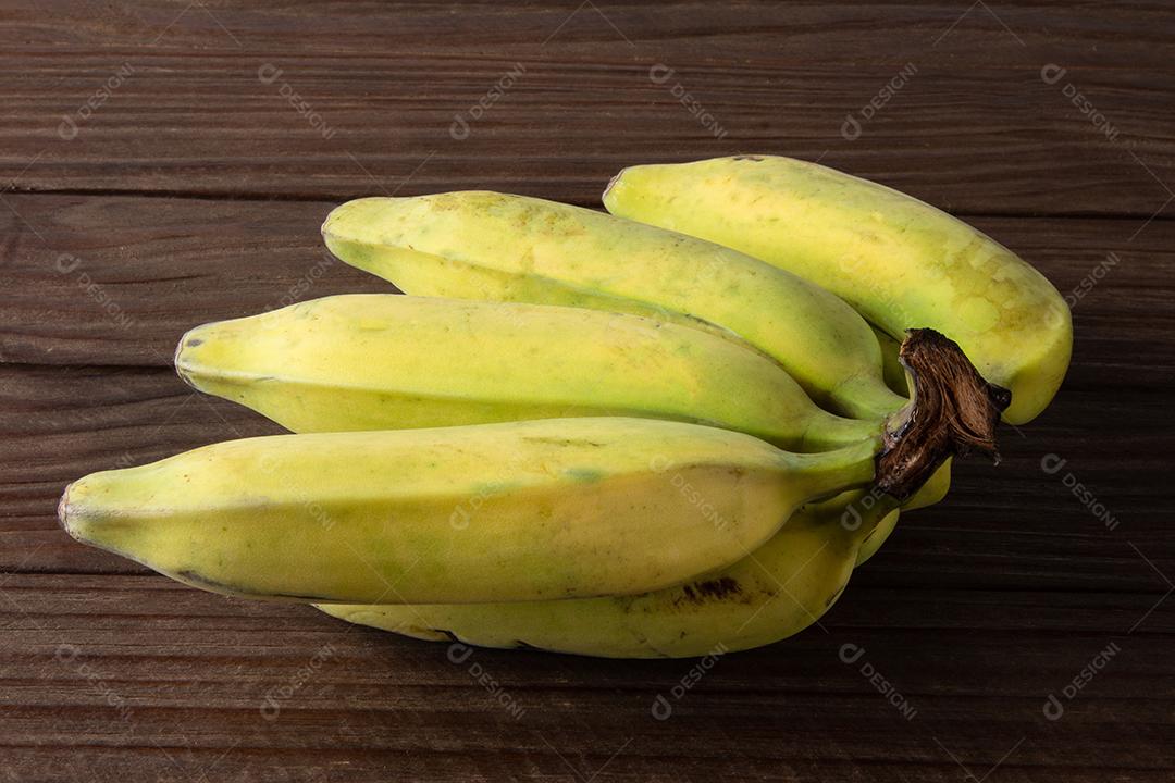 Fruta de banana madura isolada com fundo de madeira escura