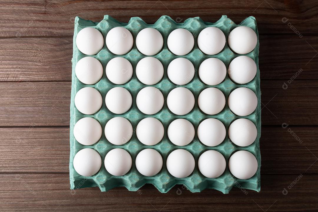 Caixa de ovos frescos isolados em fundo de madeira