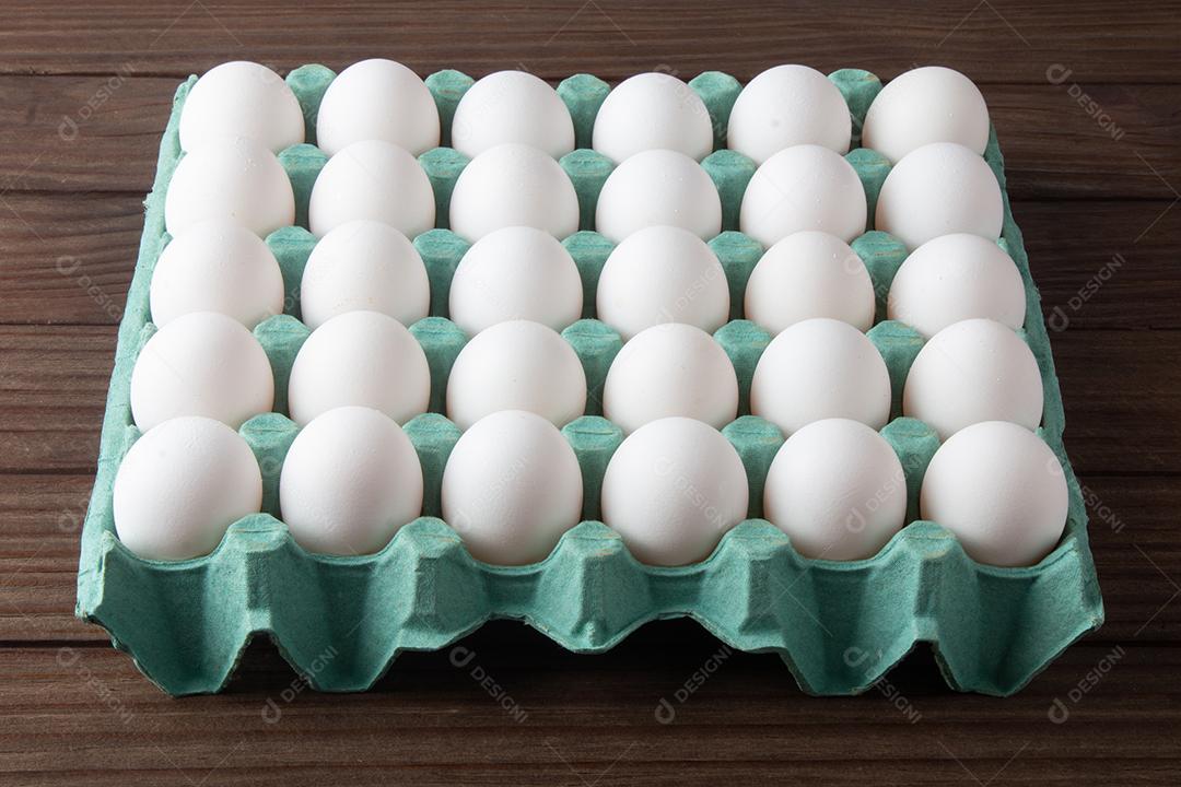 Caixa de ovos frescos isolados em fundo de madeira