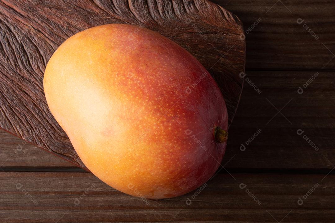 Fruta de manga madura isolada em fundo de madeira