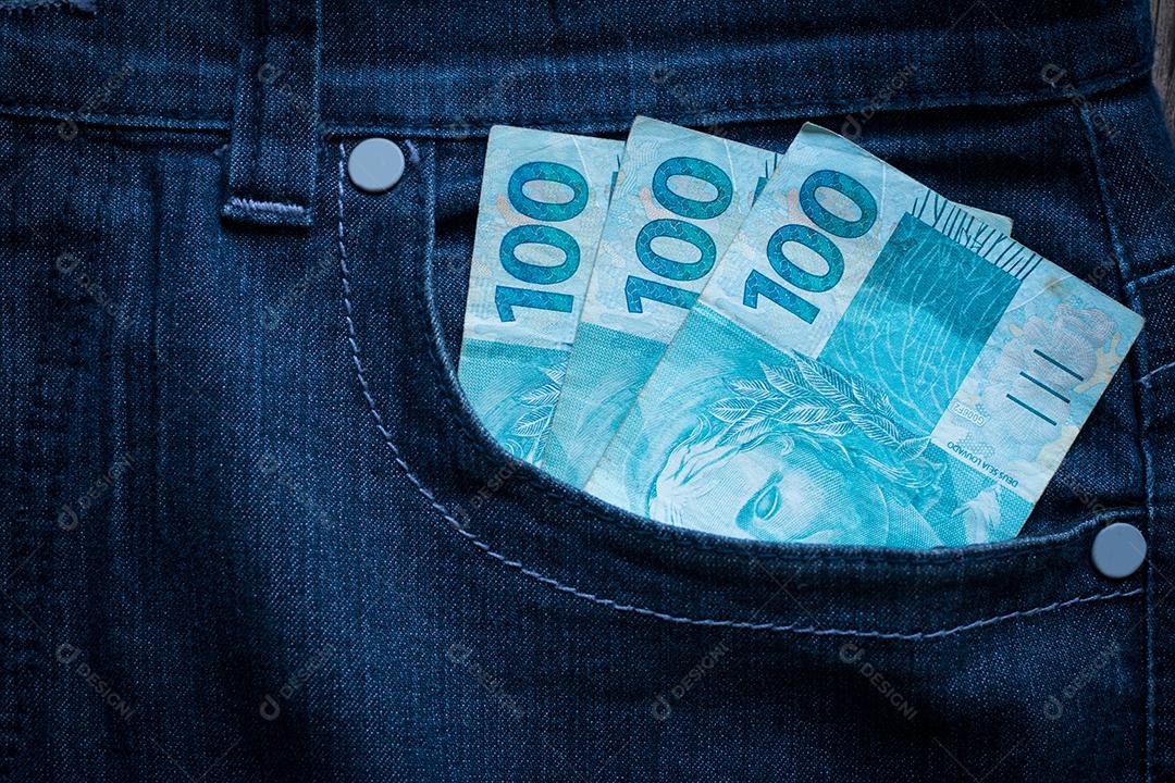 100 reais de contas no bolso jeans