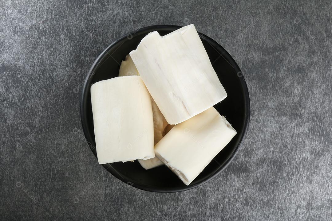 Peças de mandioca isoladas em fundo escuro