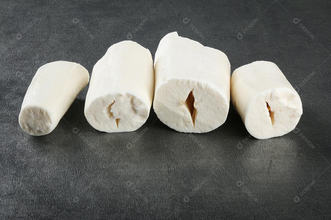 Peças de mandioca isoladas em fundo escuro