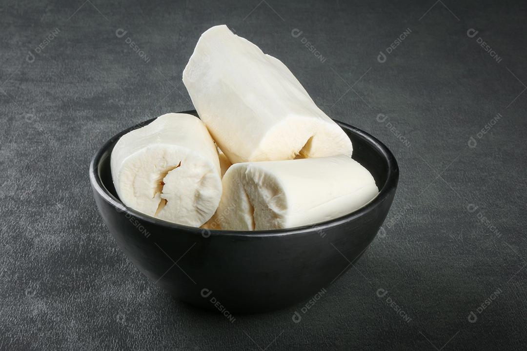 Peças de mandioca isoladas em fundo escuro