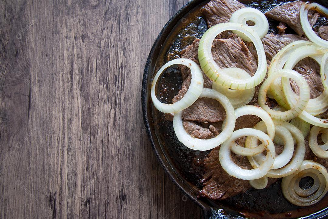 Carne frita no prato de ferro com cebola