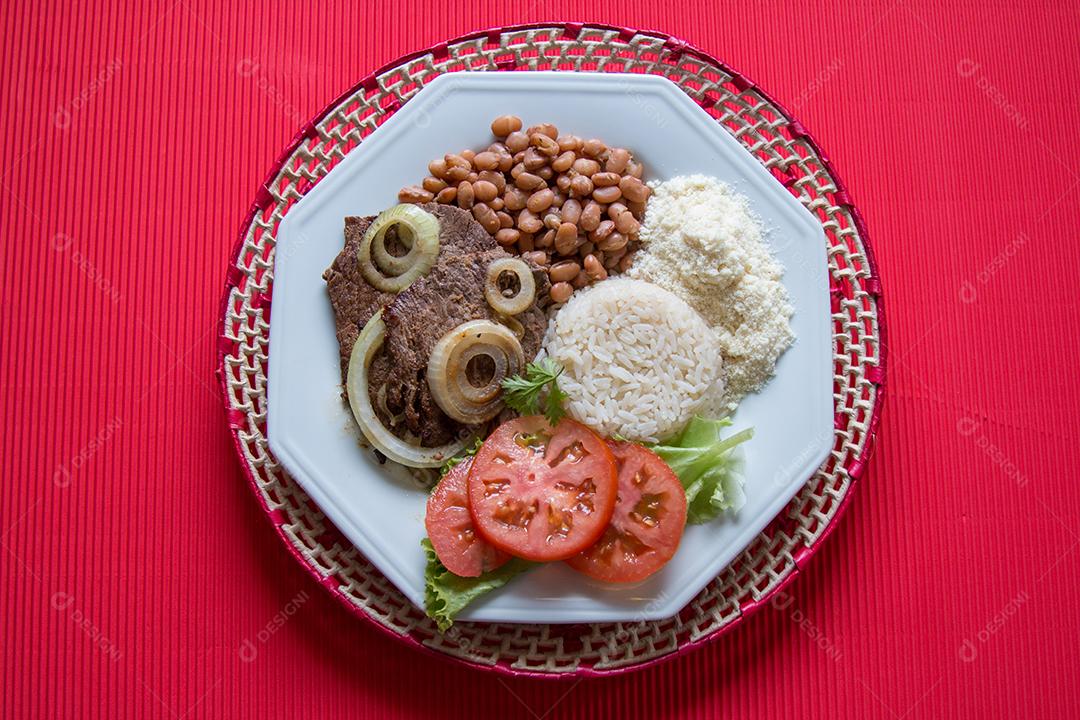 Prato de comida brasileira com fundo vermelho