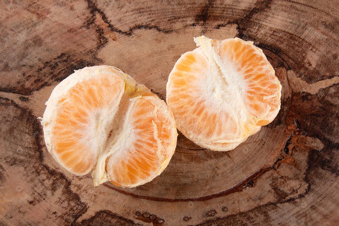 Fruta de tangerina madura com peças em fundo branco