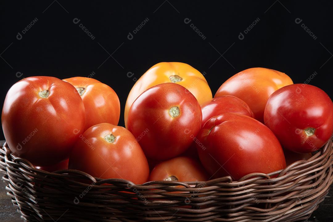 Tomate vermelho na cesta com fundo preto