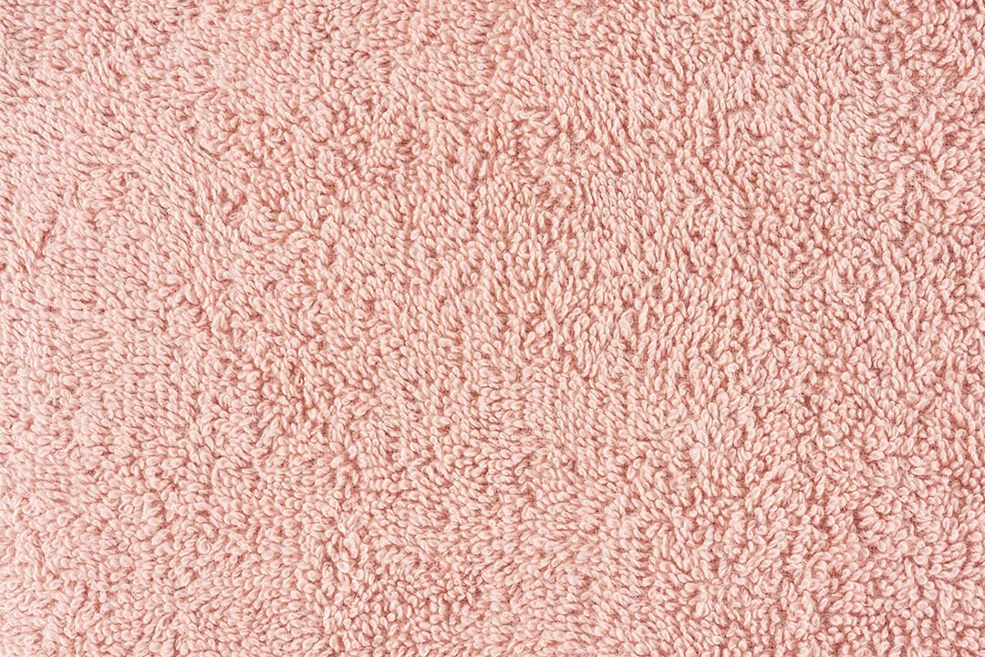Close de uma toalha rosa. pano de fundo de detalhes têxteis.