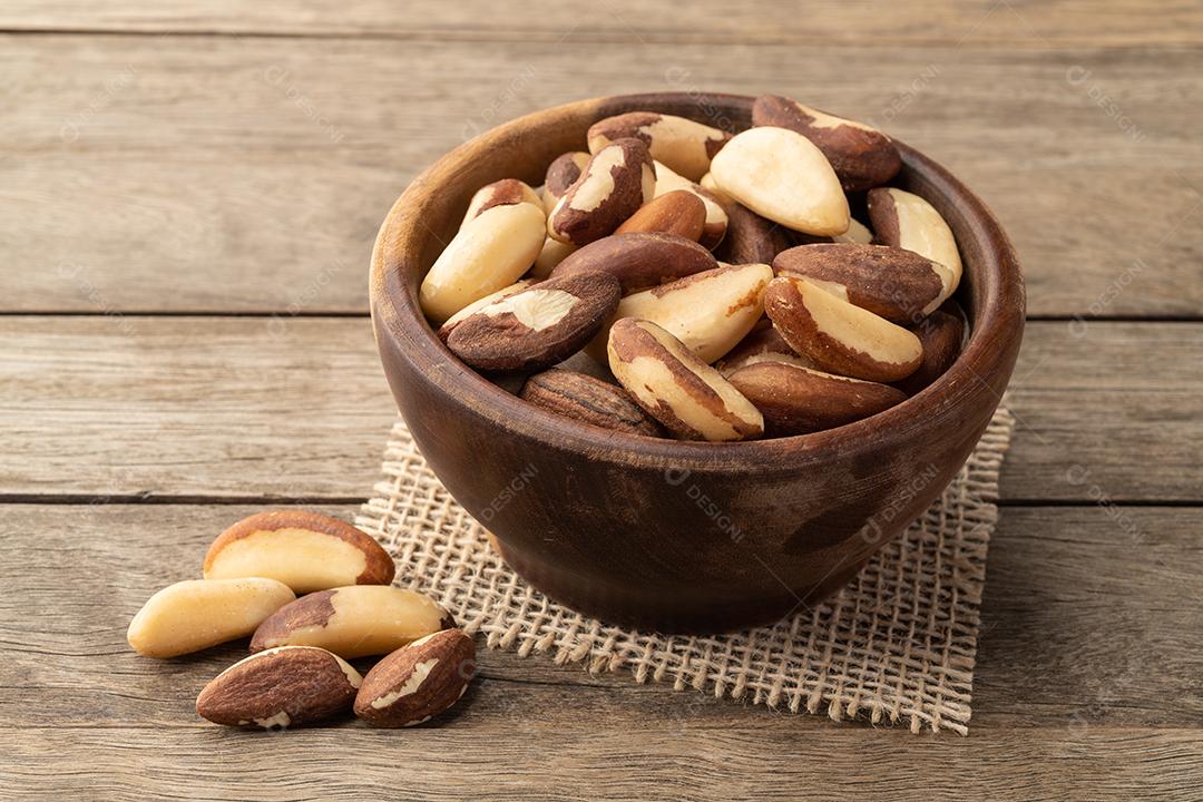 Castanhas do Brasil em uma tigela sobre a mesa de madeira.