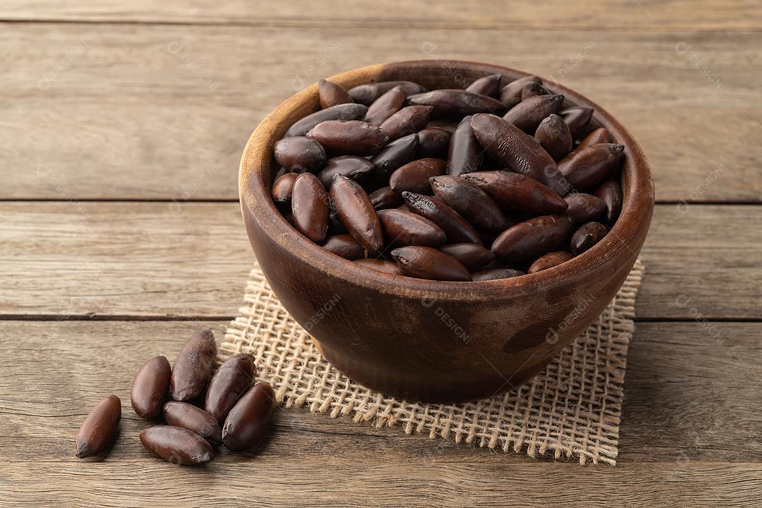 Tigela de nozes de baru brasileiro sobre a mesa de madeira.