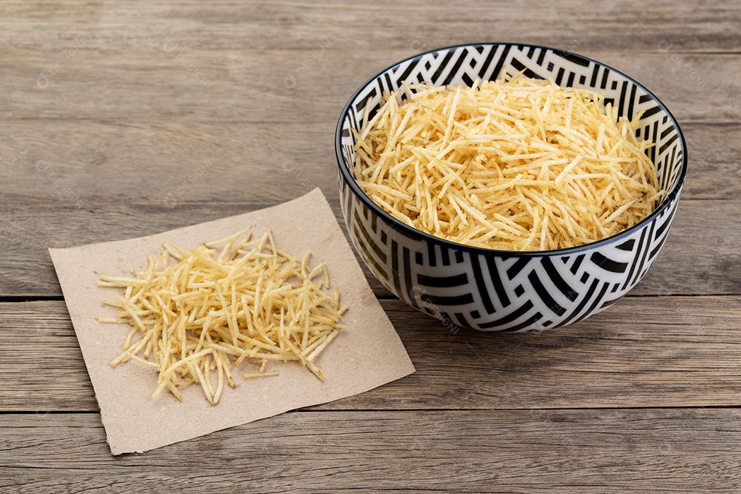 Batata palha ou batata palha em uma tigela sobre a mesa de madeira.