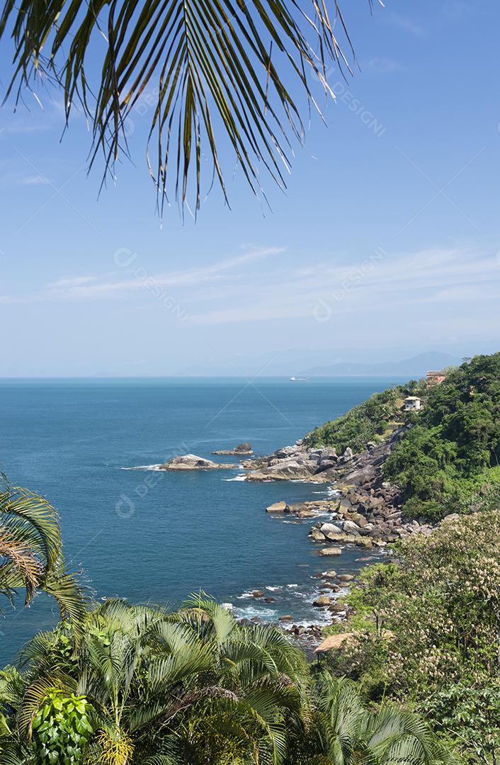 Mar azul e costa rochosa em um dia ensolarado na ilha de Ilhabela, Brasil.