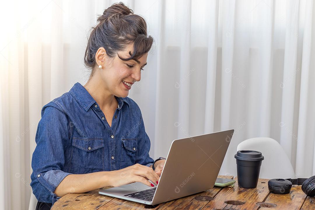 Mulher mechendo em seu notebook escritorio