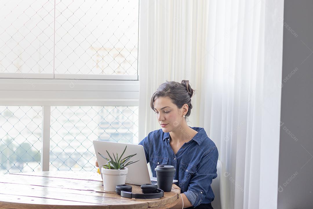 Mulher mechendo em seu notebook escritorio