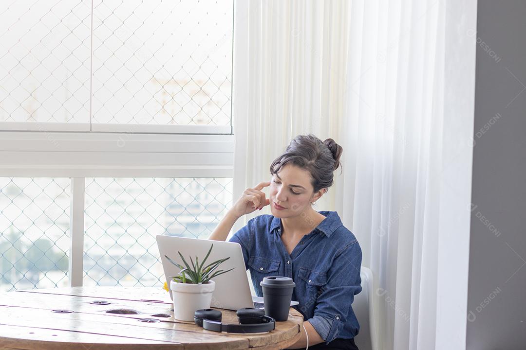 Mulher mechendo em seu notebook escritorio