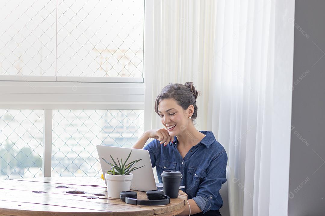 Mulher mechendo em seu notebook escritorio
