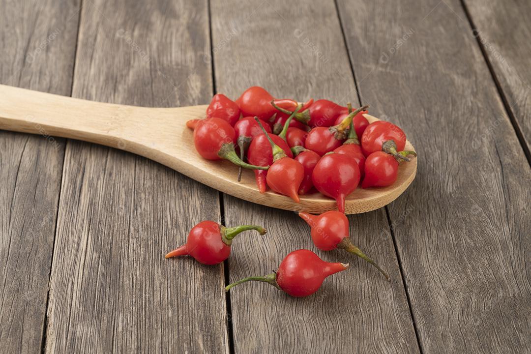 pimenta vermelha em uma colher sobre mesa de madeira