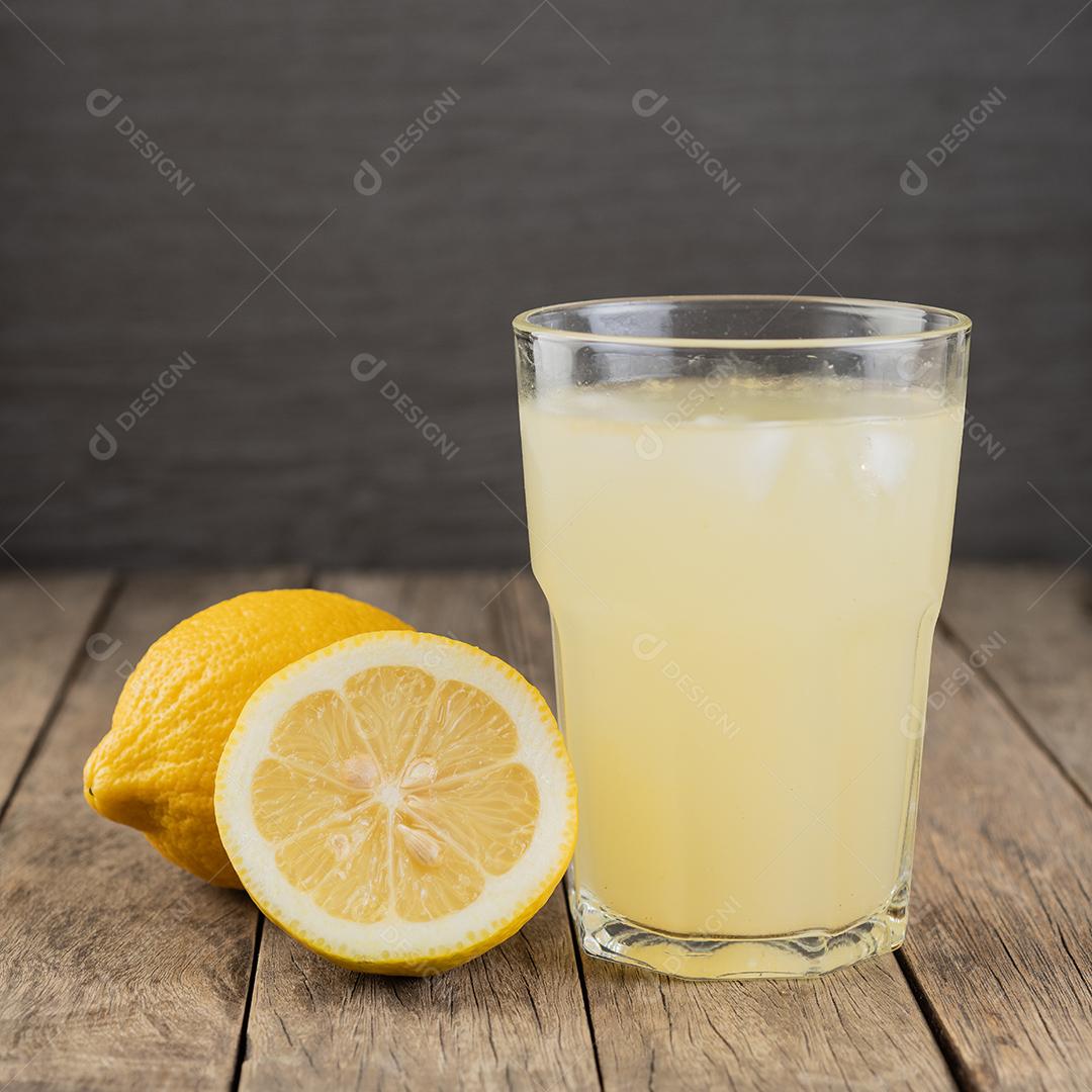 Suco de limão siciliano em um copo com frutas sobre mesa de madeira