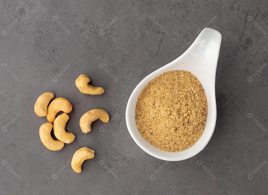 Farinha de castanha de caju em uma tigela sobre fundo de pedra. Sem glúten