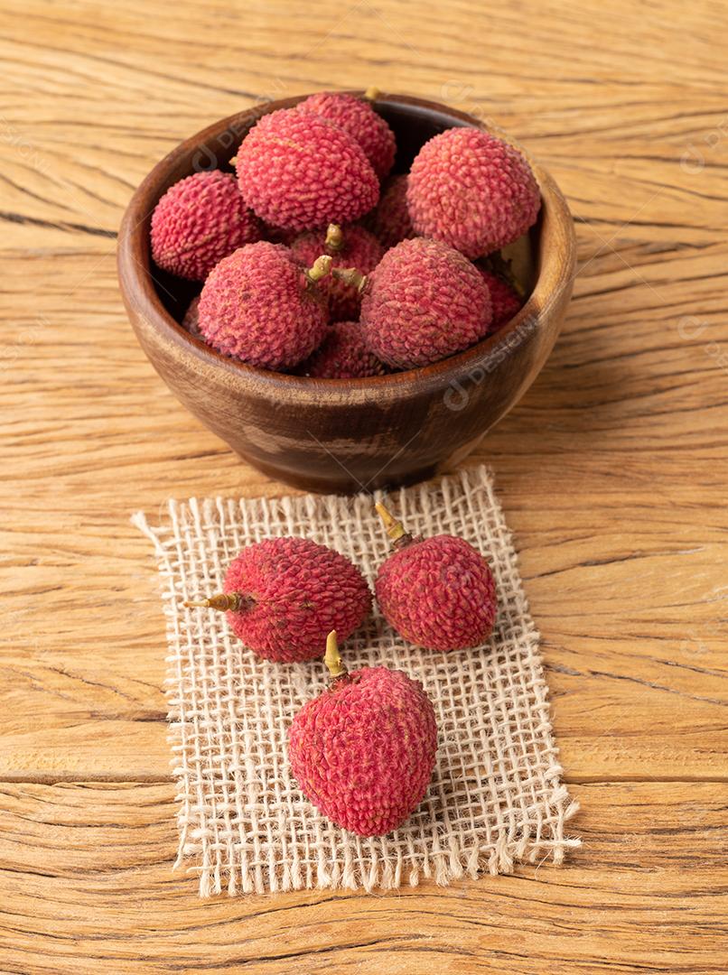 Lichias em uma tigela sobre mesa de madeira