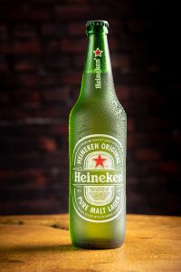 Garrafa de cerveja Heineken sobre madeira rústica