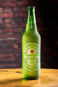 Garrafa de cerveja Heineken sobre madeira rústica